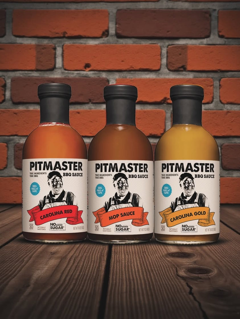 True Made Foods Pitmaster Carolina Red, Mop Sauce, and Carolina Gold BBQ sauces displayed against a brick wall background.